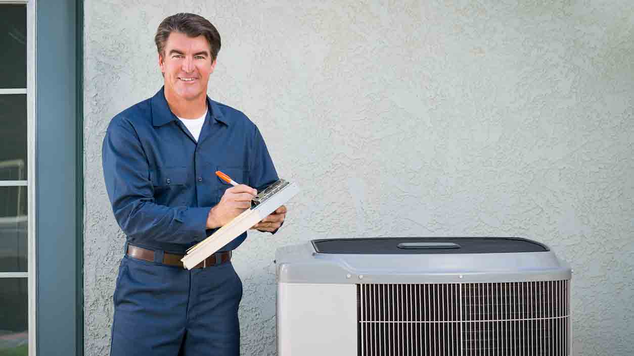 hvac technician with clipboard at outdoor ac unit