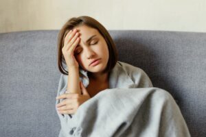 Stressed Woman Wrapped In Blanket On Couch